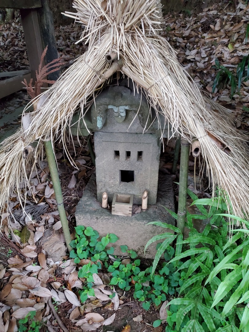 大岩毘沙門天堂向かって左側境内社群のうちの一社、茅の覆い屋が付けられた石祠
